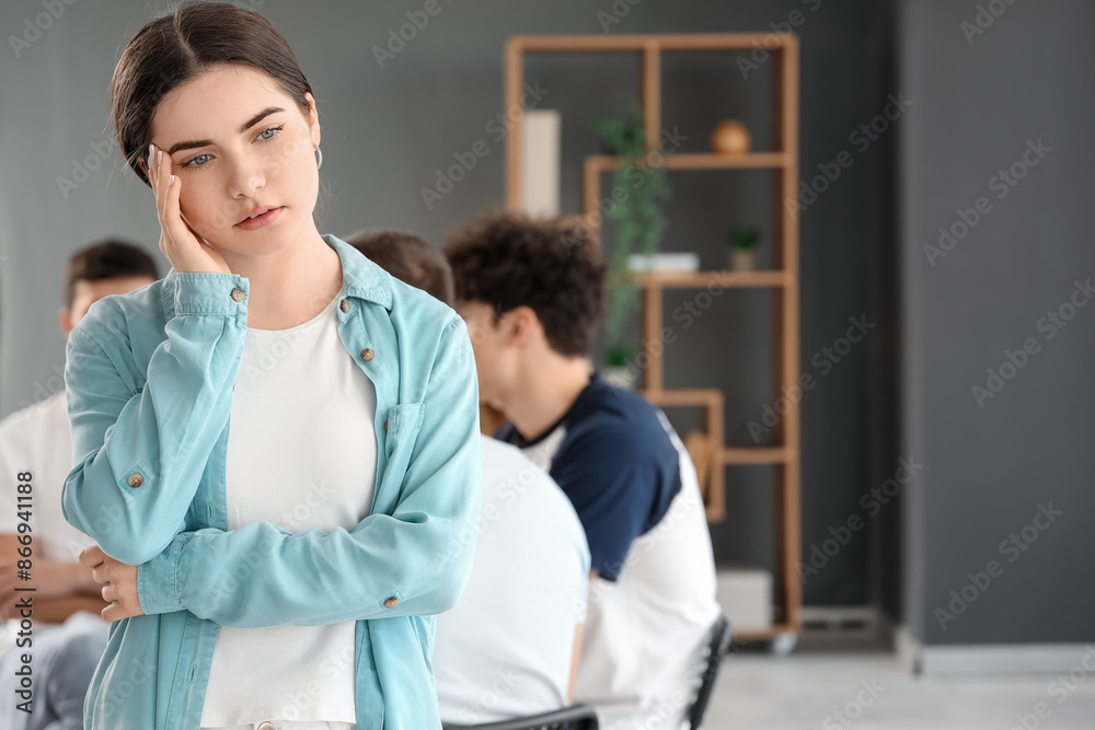 Fototapeta premium Sad young woman at group therapy session