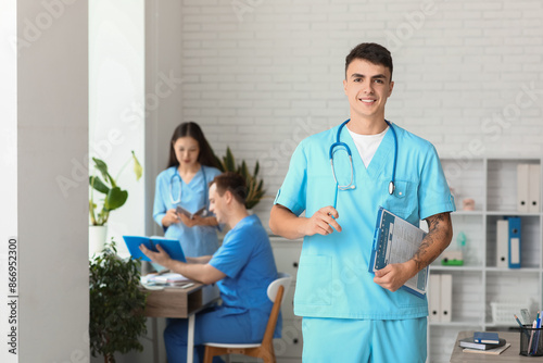Male doctor with clipboard ...