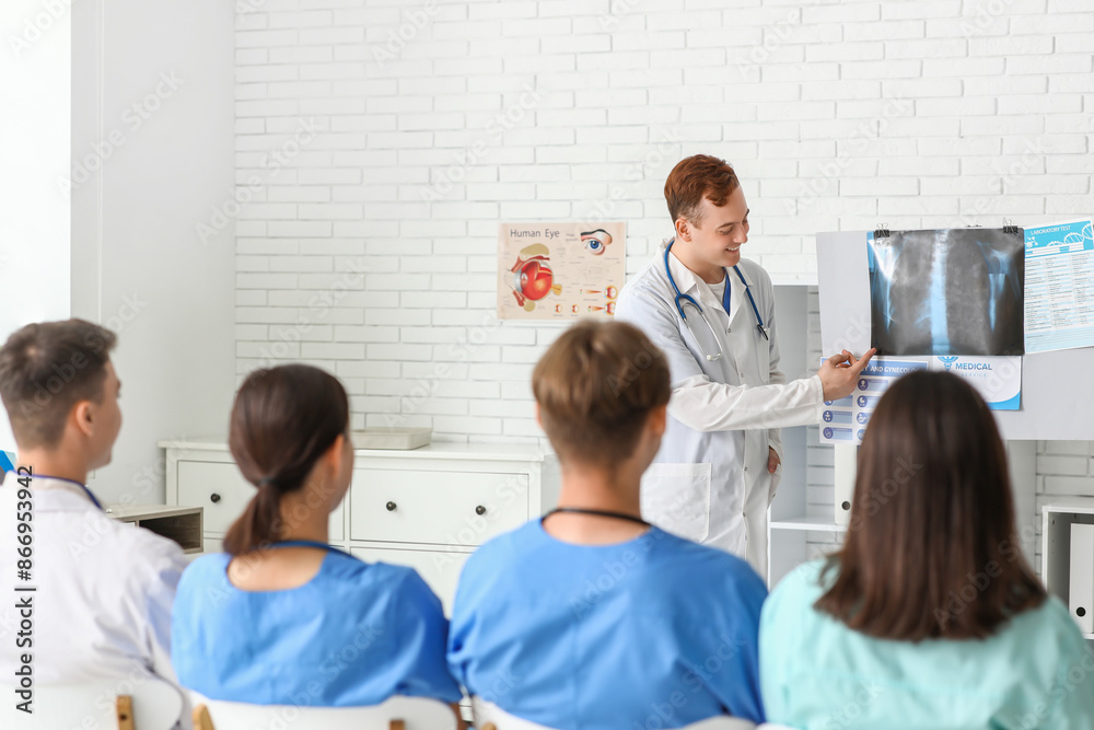 Fototapeta premium Group of young doctors studying x-ray scan of lungs in clinic