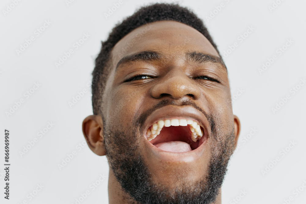 Young man expressing surprise with mouth open and tongue out, closeup of facial expression and tongue movement Young man expressing surprise with mouth open and tongue out, closeup of facial expression and tongue movement