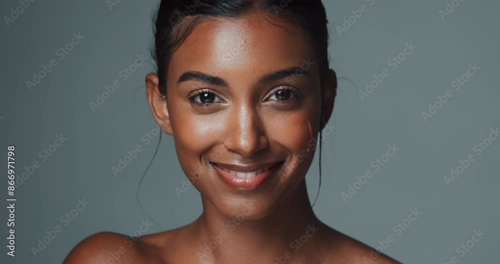 Face, skincare and Indian woman with natural serum for collagen in studio isolated on gray background. Portrait, smile and model apply dropper for cosmetics, dermatology and vitamin c for beauty