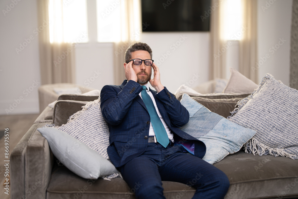 Fototapeta premium Overworked burnout man feeling migraine head strain. Tired bored business man has office syndrome. Exhausted man with migraine or headache. Office worker, manager or freelancer having a headache.