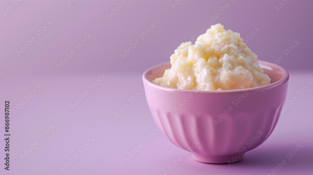 Creamy rice pudding served in pink bowl with neutral background Creamy rice pudding served in pink bowl with neutral background