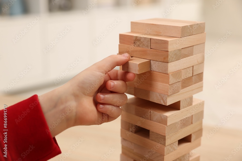 Child playing Jenga at table indoors, closeup Child playing Jenga at table indoors, closeup