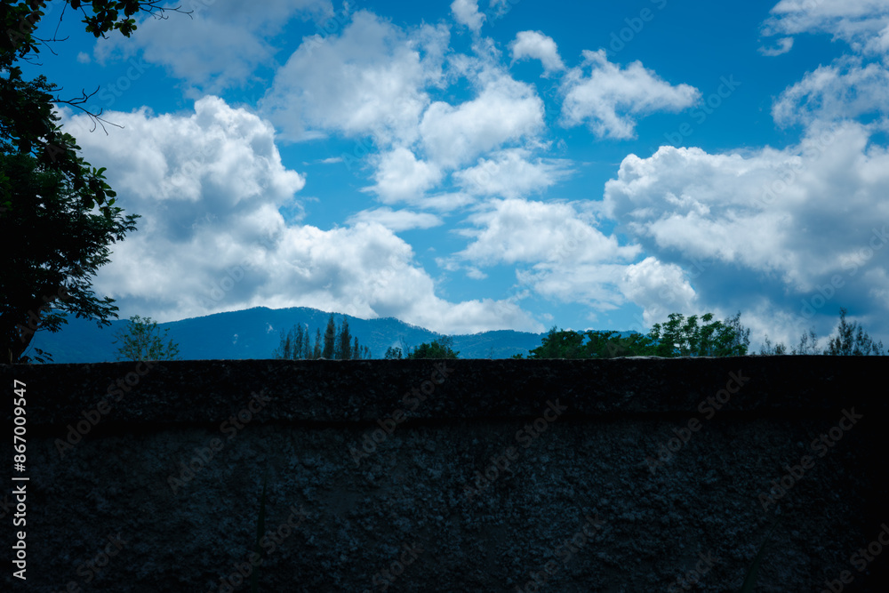 A mountain range is visible in the distance behind a wall A mountain range is visible in the distance behind a wall