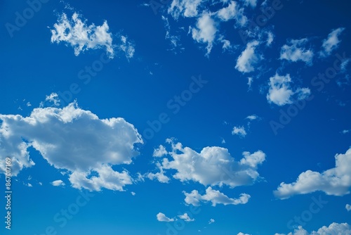 White fluffy clouds are slowly drifting on a deep blue sky