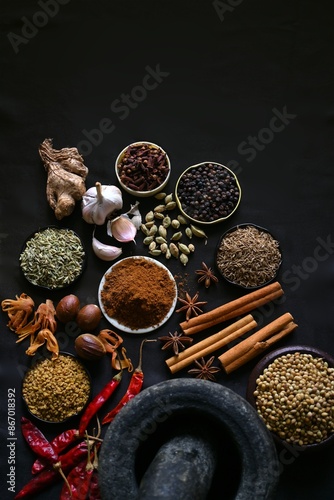 Fototapeta Naklejka Na Ścianę i Meble -  Indian traditional spice blend, masala powder with ingredients and mortar and pestle isolated on black background