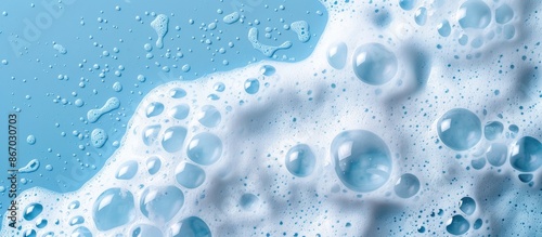 White foamy texture on a blue backdrop. Cleansing foam for face, bath bubbles, or laundry detergent. Macro shot with empty space.