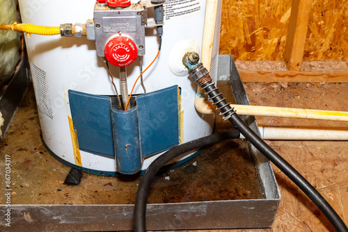 Hose connected to water heater drain, water in catch pan