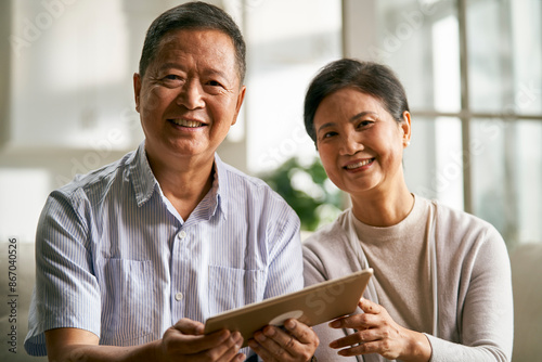 senior asian couple using digital tablet together at home