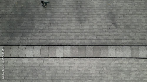 flying above a roof with shingles (horizontal moving footage drone shot looking down from above bird's eye view) aerial inspection of roofing structure construction inspector photo