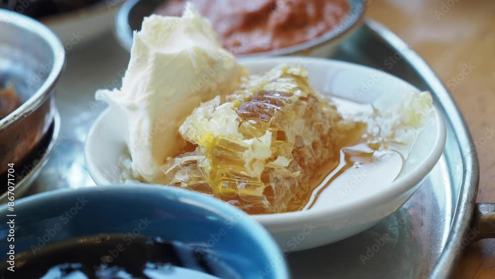 butter cream and honey in a bowl on table .