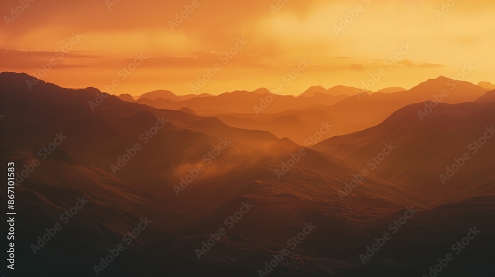 Naklejka premium Beautiful sunset over mountains with warm orange and yellow tones, creating a serene and picturesque landscape view.
