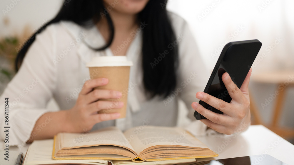woman using mobile phone while drinking coffee in cafe woman using mobile phone while drinking coffee in cafe