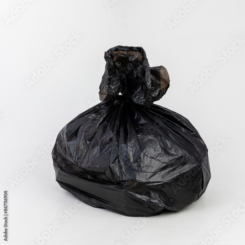 Black trash bag against a white background shot inside a studio.