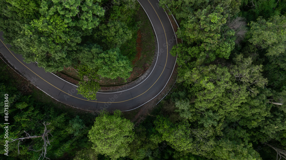 Aerial view countryside asphalt road curve passing through the green forest and mountain, Road curve in the middle of the jungle green forest, Curve road in woodlands outdoor adventure trip. Aerial view countryside asphalt road curve passing through the green forest and mountain, Road curve in the middle of the jungle green forest, Curve road in woodlands outdoor adventure trip.