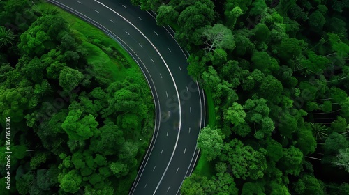 Aerial view of a highway cutting through lush green forest, smooth asphalt, winding road, vivid greenery, expansive and detailed landscape