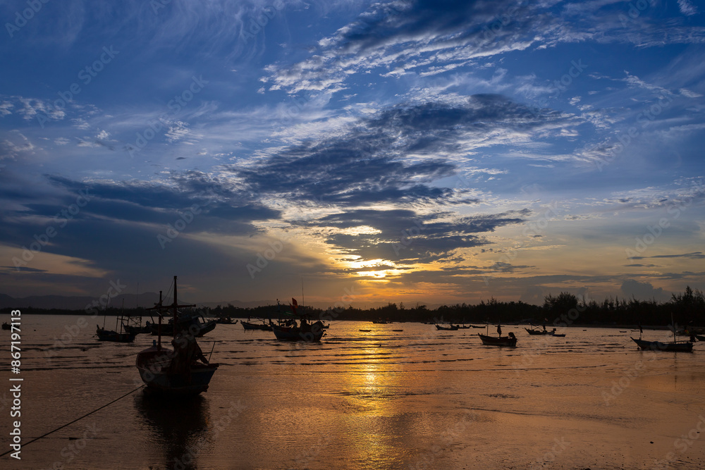 Fishing Wood boat on peaceful calm relaxing on a Beautiful evening landscape with orange sky reflecting on the seawater at sunset Fishing Wood boat on peaceful calm relaxing on a Beautiful evening landscape with orange sky reflecting on the seawater at sunset