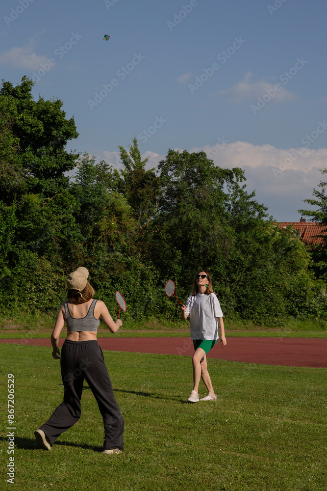 Two Women Playing Badminton on a Grass Field Two Women Playing Badminton on a Grass Field