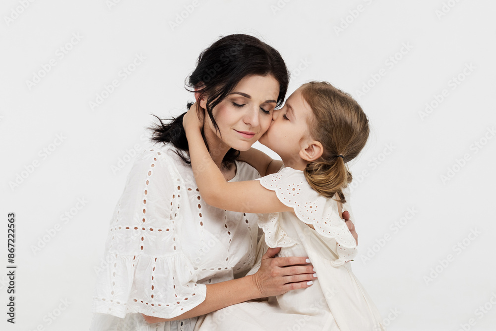 Close-up of touching and tender interaction between mother and daughter on a light background. Mom's gentle touch. Family concept. Close-up of touching and tender interaction between mother and daughter on a light background. Mom's gentle touch. Family concept.