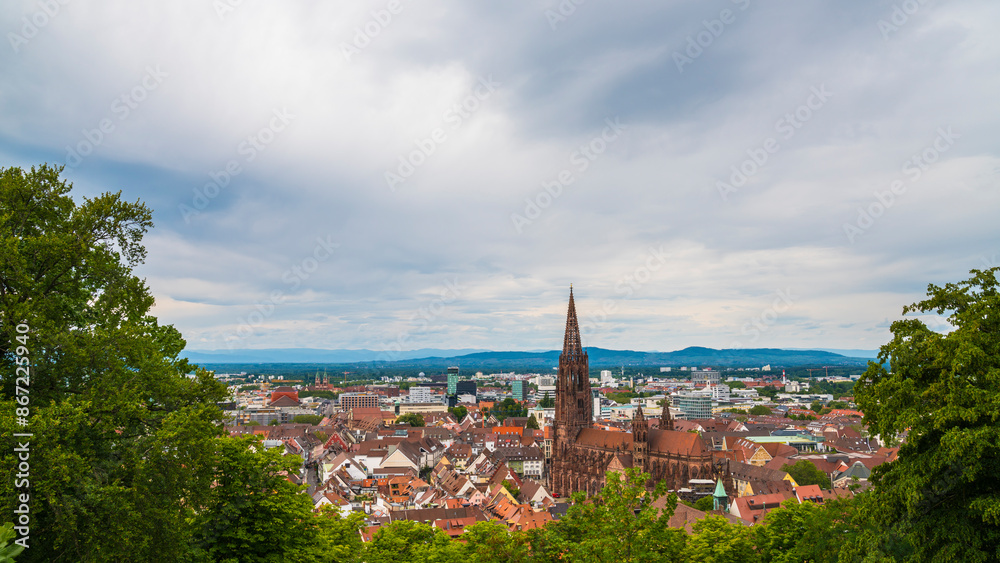 Germany, Freiburg im Breisgau aerial panorama view above old town houses, marketplace, red roofs and historical muenster cathedral building