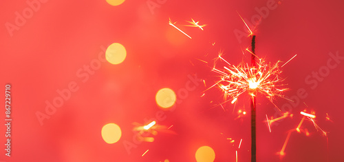 Beautiful sparklers from sparklers on a red background of New Year's bokeh, Christmas mood, glitter, holiday background. Happy New Year! Happy holiday! 