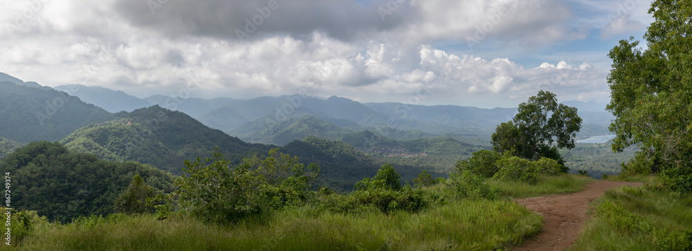 Glued high resolution panorama of tropical landscape: a country road, many hills covered with jungle behind. Dense vegetation, a nice summer day. Glued high resolution panorama of tropical landscape: a country road, many hills covered with jungle behind. Dense vegetation, a nice summer day.
