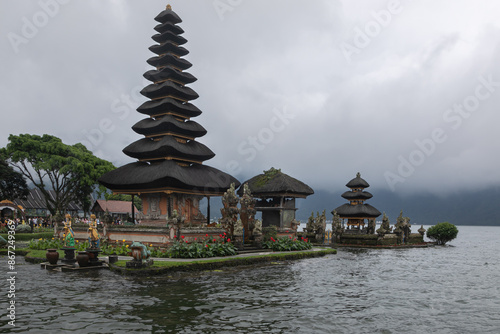 Pura Oolong Danu Bro Bedugul is a Hindu temple on the Indonesian island of Bali. Sacred building is on the shore of Lake Beratan. Mystical fog around, mountains with a tropical forest in the distance