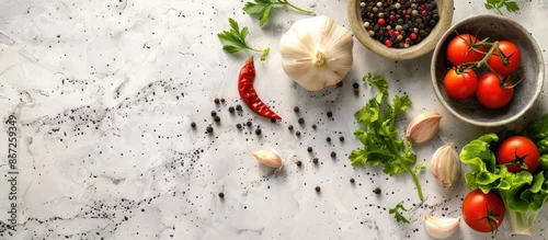 Panel kuchenny z motywem Ingredients such as black pepper, garlic, onion, greens, and tomatoes arranged on a white stone concrete table with ample space for cooking.
