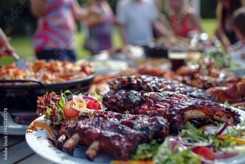 A table set with a variety of barbeque dishes, including ribs, chicken, and salads. People in the background serve themselves, enjoying the delicious spread at the barbeque party, blurred background
