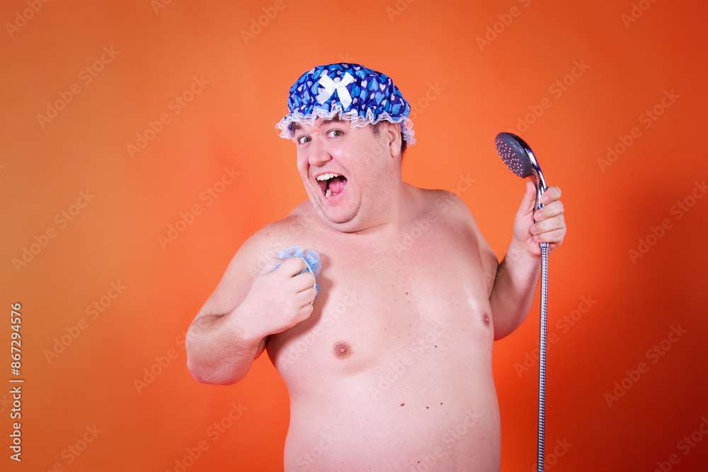 Funny fat man in the shower. Orange background. Funny fat man in the shower. Orange background.