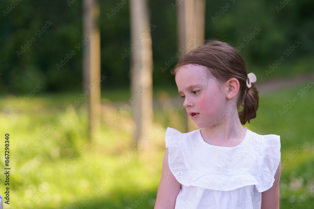 A cute girl, missing one tooth, playing joyfully in the summer heat at the playground. A cute girl, missing one tooth, playing joyfully in the summer heat at the playground.