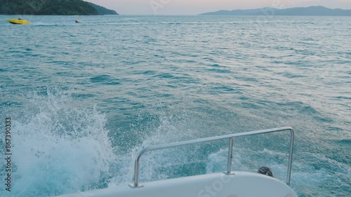 Group of diverse people having fun jumping in the sea water from the yacht during summer.Friends in swimming costume hopping at boat ladder of yacht while yachting in sunny day. Friendship concept