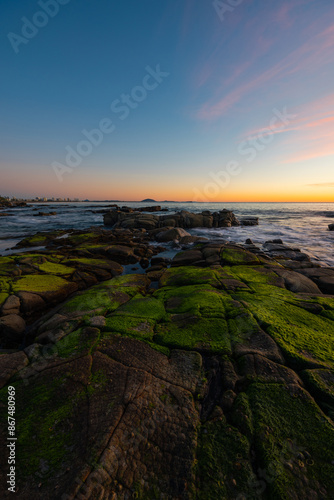 Mossy rocks on the beach shore.