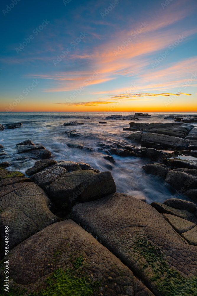 Obraz premium Water flowing around the rocky coastline.