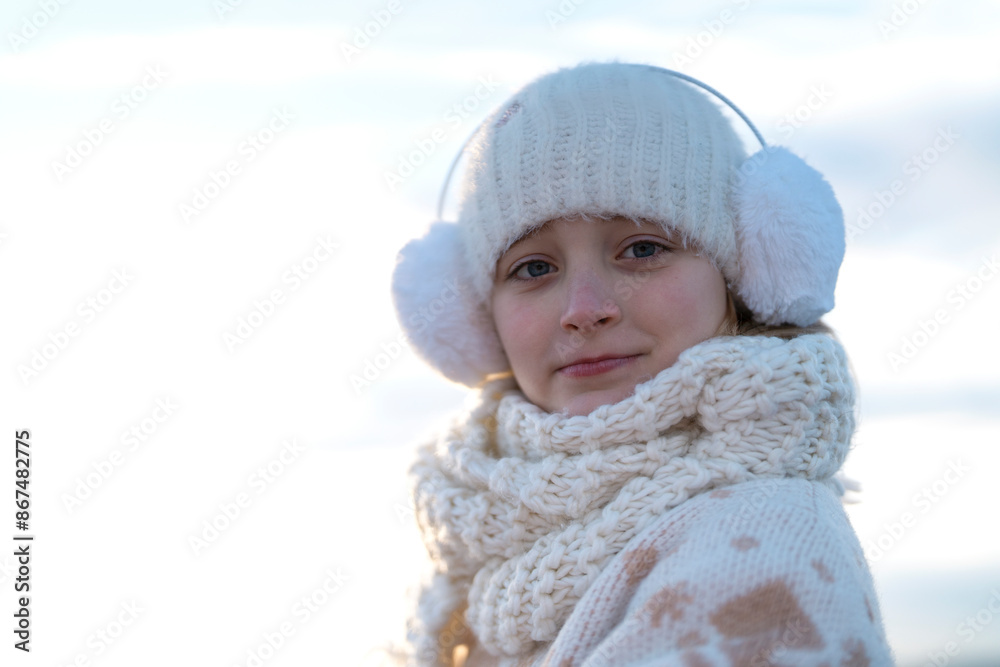 Girl Wearing Earmuffs and Knitted Scarf in Winter Girl Wearing Earmuffs and Knitted Scarf in Winter