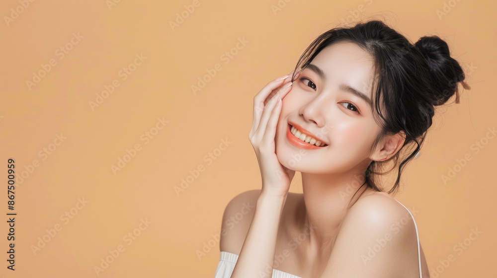 A radiant Asian woman smiles brightly against a peach background, providing ample copy space for skincare product advertising. Skincare, Beauty, Fashion, Body care and Cosmetics concepts A radiant Asian woman smiles brightly against a peach background, providing ample copy space for skincare product advertising. Skincare, Beauty, Fashion, Body care and Cosmetics concepts