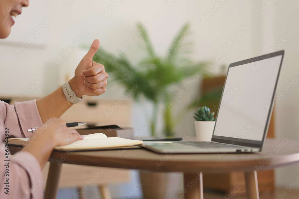 Female entrepreneur meeting and showing thumb up with partners in video call while working at home Female entrepreneur meeting and showing thumb up with partners in video call while working at home