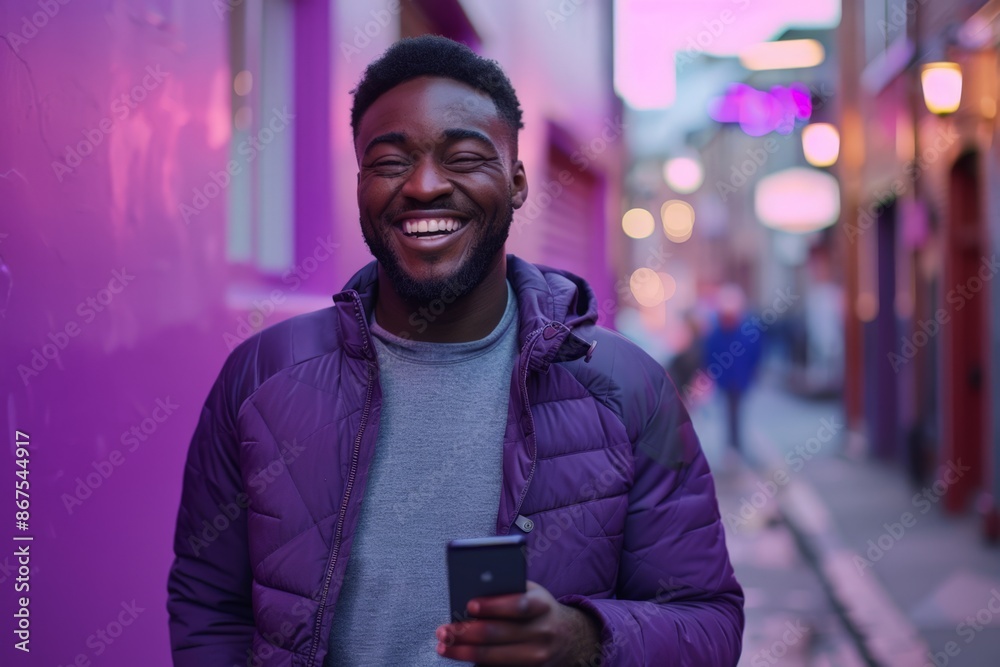 Smiling Man in Purple Jacket, Holding Phone on City Street Smiling Man in Purple Jacket, Holding Phone on City Street