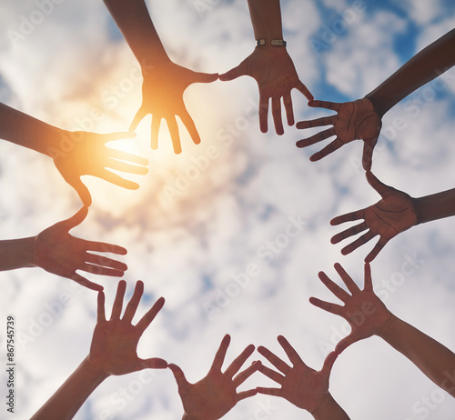 Sky, circle and hands of people together for community, collaboration and teamwork outdoors. Diversity, solidarity and low angle of group with cloud background in nature for trust, charity or support