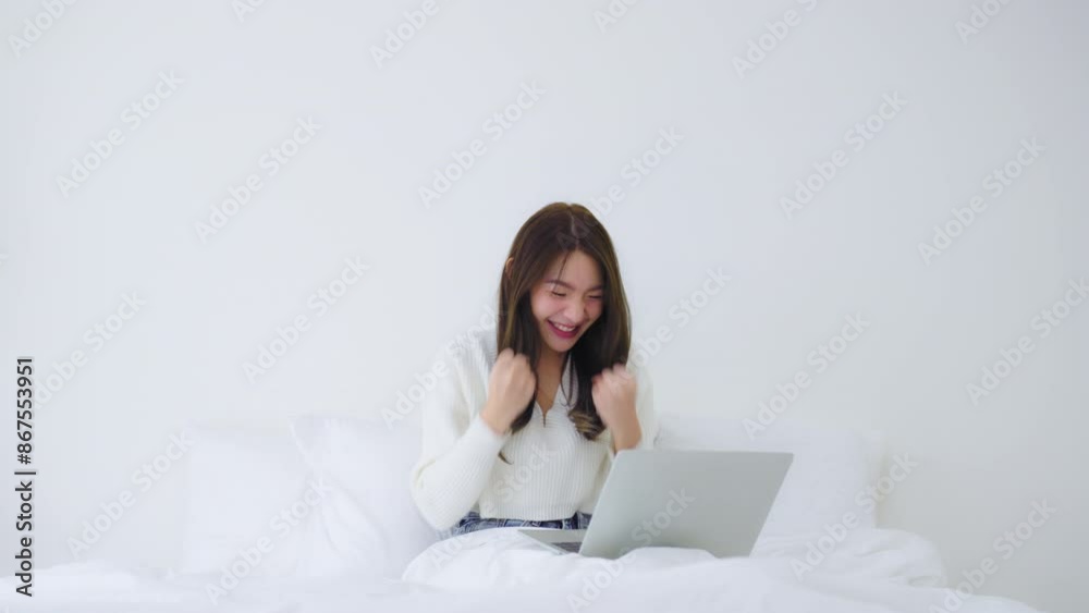 Happy young asian woman using computer laptop on bed in bedroom Happy young asian woman using computer laptop on bed in bedroom