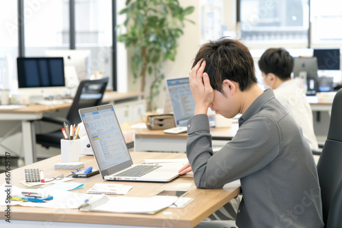 PCの前で頭痛がしている若手社員　Generative AI