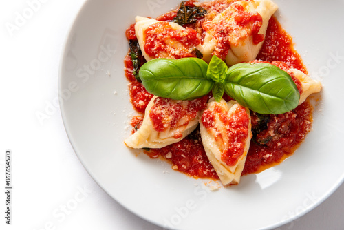 Fototapeta Naklejka Na Ścianę i Meble -  Piatto di deliziosi culurgiones ogliastrini isolato su fondo bianco, tipica pasta ripiena di pecorino, patate e menta della cucina Sarda, cibo italiano, gastronomia europea 