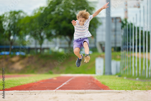 Kids long jump athletics training. Child jumping.