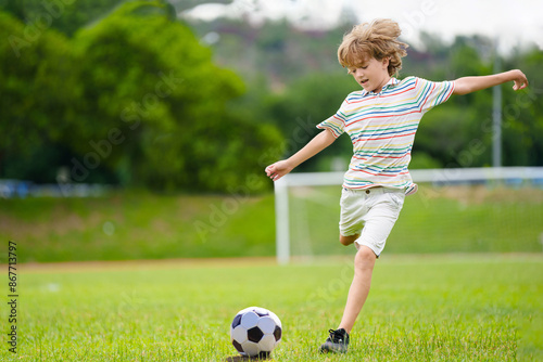 Child playing football. Kids play soccer. © famveldman