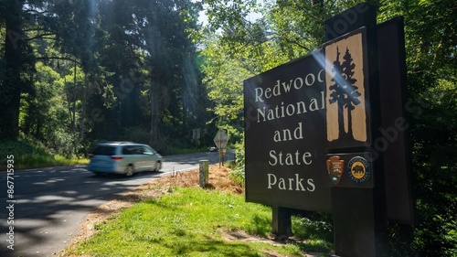 Crescent City, Califfornia - 5-9-2024:Redwood National and State Park entrance sign with motion blurred carHighway 101, California