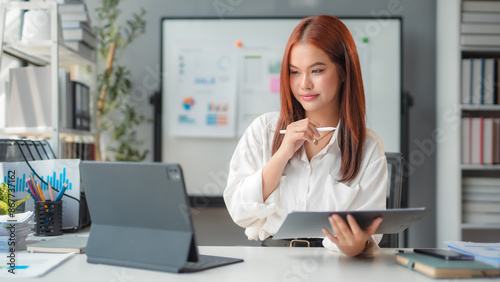 Asian businesswoman thinking while working at office desk