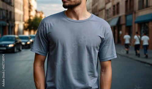 Muscular man wearing a trendy T-shirt while standing by a bustling city street, Print T-shirt Mockup © FreemiumStock