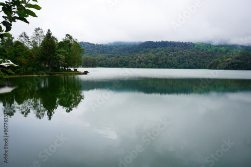 Serene Calm Lake Reflecting Misty Forest in the Morning in Lembang photo