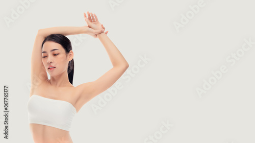 Young asia slim woman black hair and clear skin posing gracefully, arms raised and eyes closed, showcasing natural beauty and elegance against a white background. Ideal for beauty, skincare, wellness